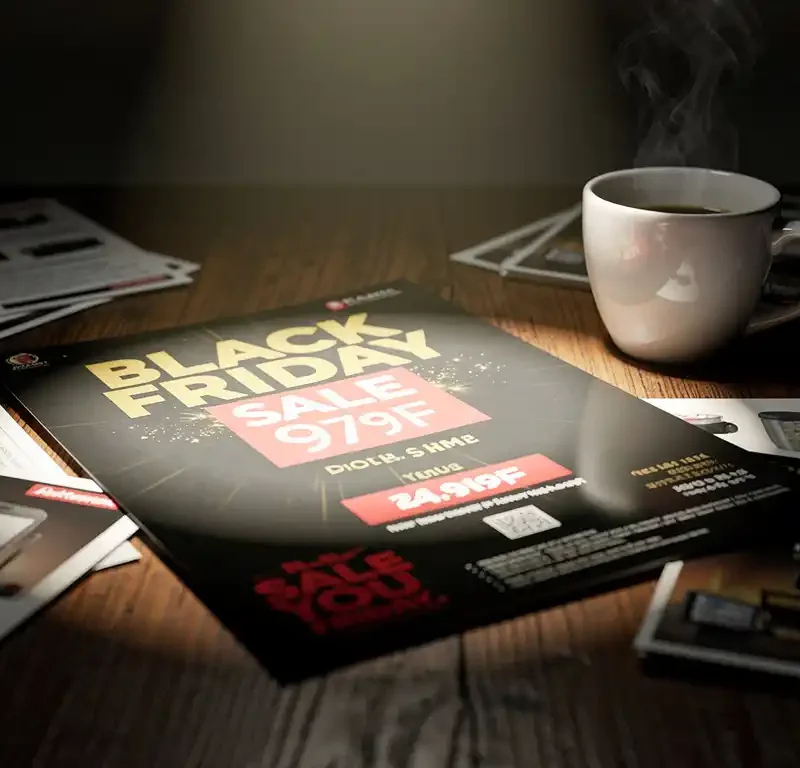 Black Friday -myyntiflyer tummalla puupöydällä, ympärillä esitteitä ja höyryävä kahvikuppi, musta-kultaiset sävyt.