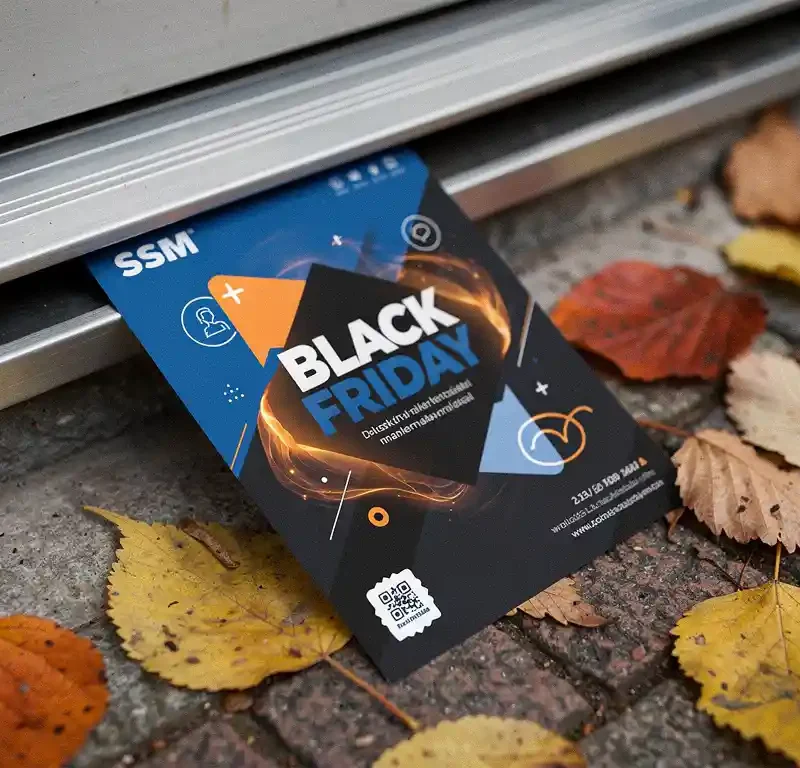 Kiiltävä Black Friday -mainoslehtinen putoaa postiluukulle, syksyn lehtiä suomalaisen oven edessä pehmeässä pohjoismaisessa valossa.